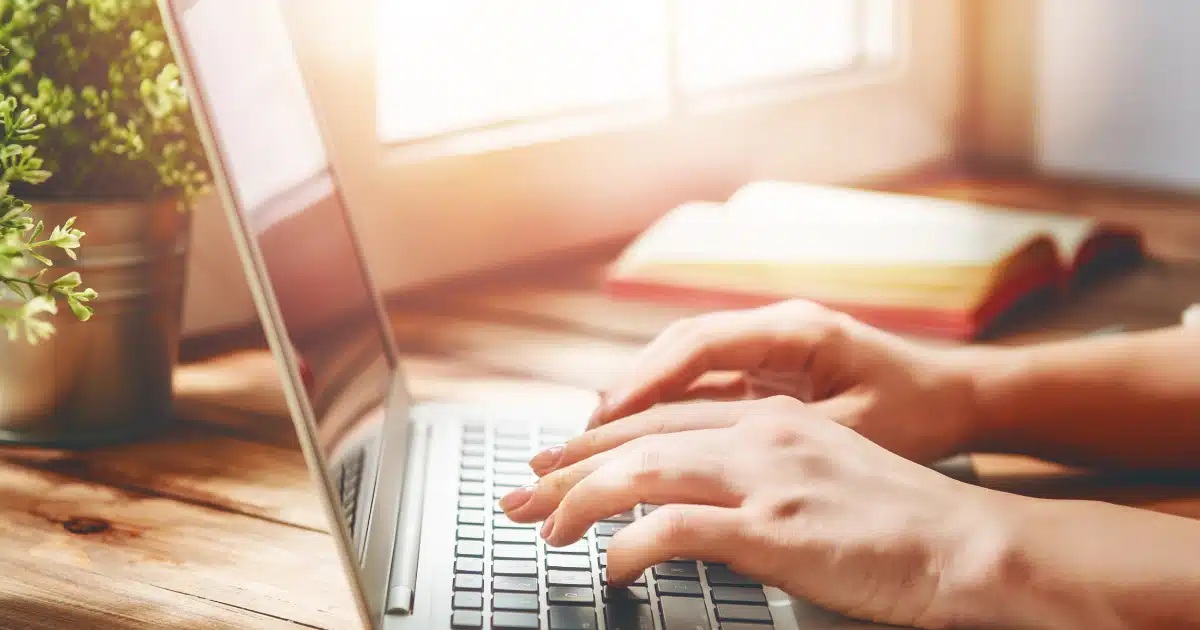 photo d'un mains de femmes en train de taper sur un clavier d'ordinateur portable pour illustrer une coahc seo