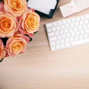 photo d'un clavier avec bouquet roses oranges pour illustrer le métier de rédacteur web seo