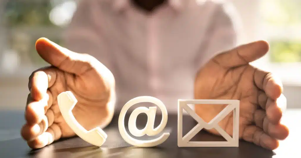photo avec un homme qui met en valeur des logos : téléphone, mail et courrier pour illustrer mes 9 conseils pour rédiger une page contact.
