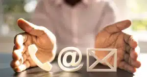 photo avec un homme qui met en valeur des logos : téléphone, mail et courrier pour illustrer mes 9 conseils pour rédiger une page contact.