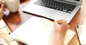 photo d'une personne en train d'écrire sur un carnet pour mettre en place une stratégie seo facile